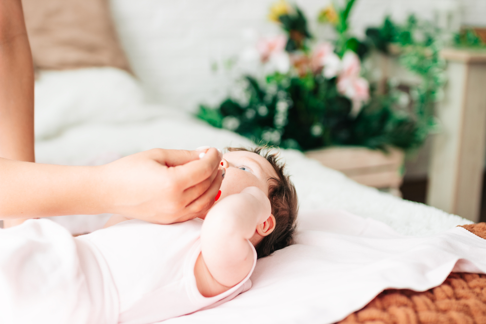 Mamma effettua i lavaggi nasali al neonato