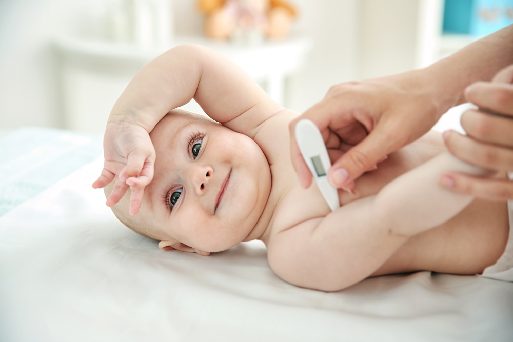 neonato sorridente con il termometro
