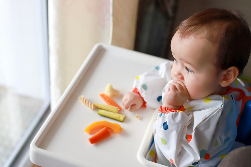 Bambino che mangia verdure nello svezzamento