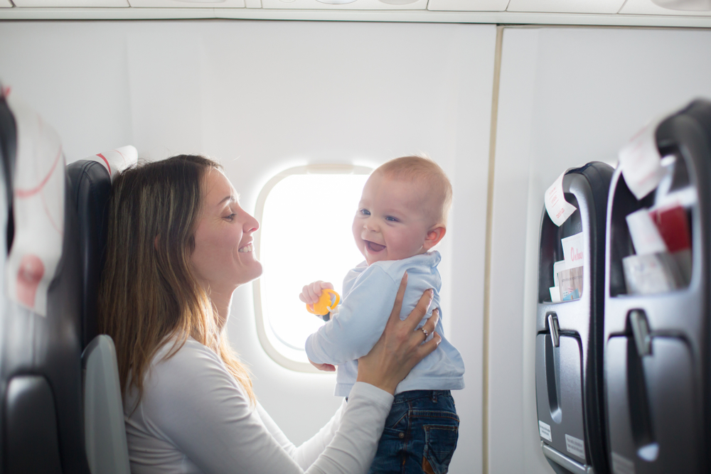 Neonato felice sull'aereo con la sua mamma