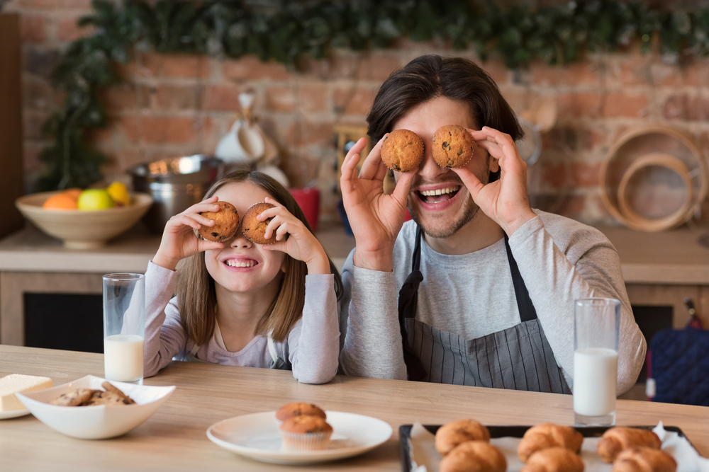 Papà e figlia si divertono in cucina con dei muffin fatti in casa