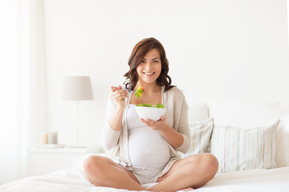 Donna in gravidanza che mangia un'insalata sana