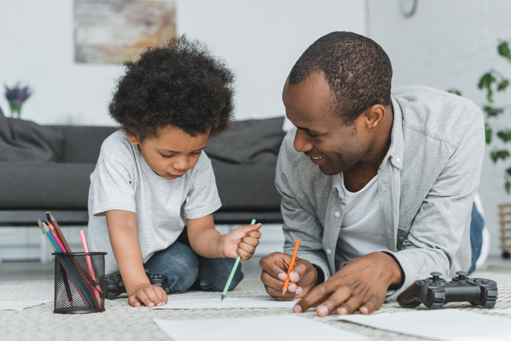 Papà aiuta il suo bambino a imparare a disegnare