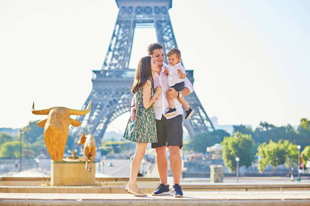Coppia in viaggio di nozze a Parigi con il proprio piccolo, davanti alla Torre Eiffel
