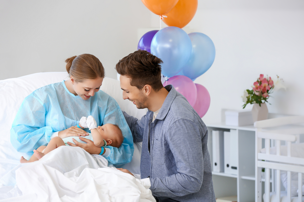 Genitori in ospedale che guardano il bambino appena nato in braccio alla madre