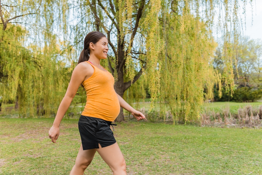 Donna incinta che cammina all'aperto nel parco