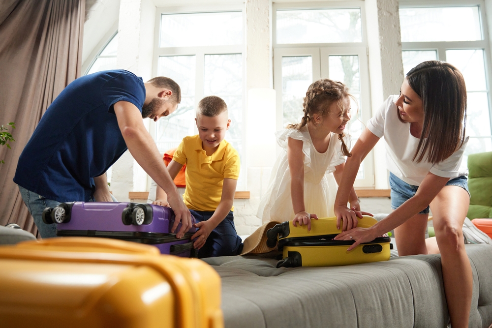 Genitori e figli in camera da letto che preparano le valigia per il campeggio