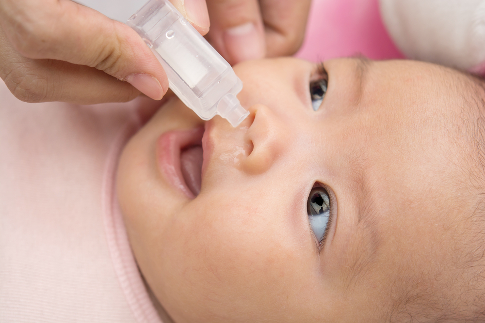 Pulizia nasale di un neonato con gocce saline